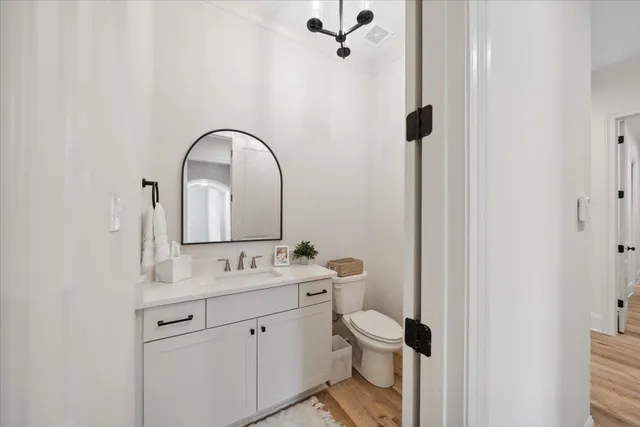 a bathroom with a granite countertop sink a toilet and a mirror