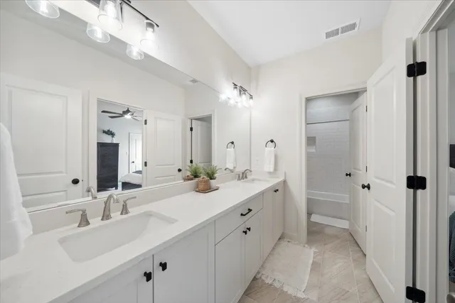 a bathroom with a double vanity sink mirror and next to a window