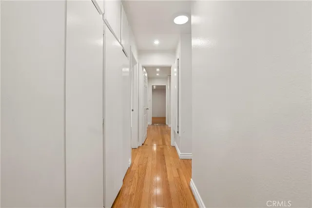 a view of a hallway with wooden floor and staircase