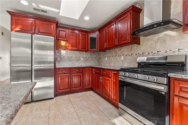 a kitchen with stainless steel appliances granite countertop a stove a sink and a refrigerator