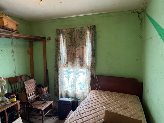 a bedroom with a bed window and a mirror