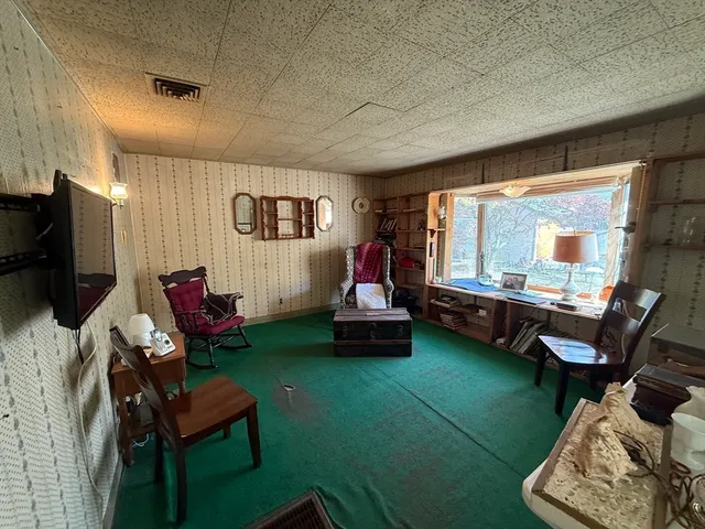 a living room with furniture a flat screen tv and a large window