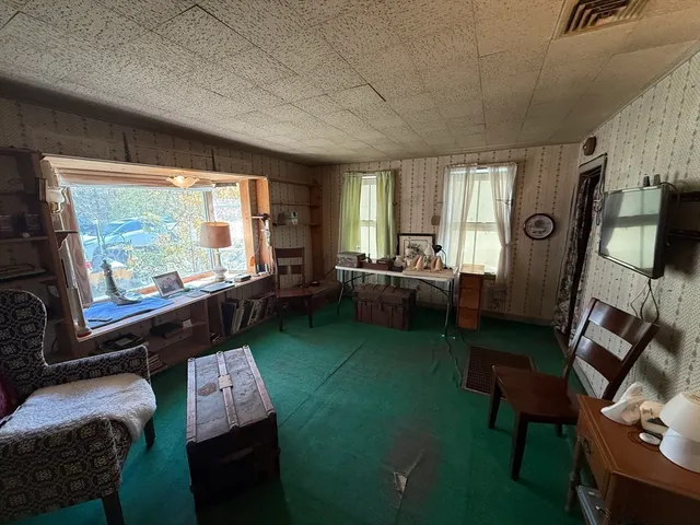 a living room with furniture a flat screen tv and a floor to ceiling window