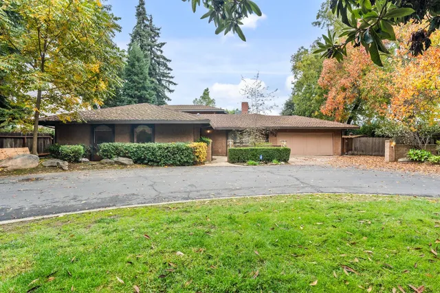 a front view of a house with a yard and potted plants