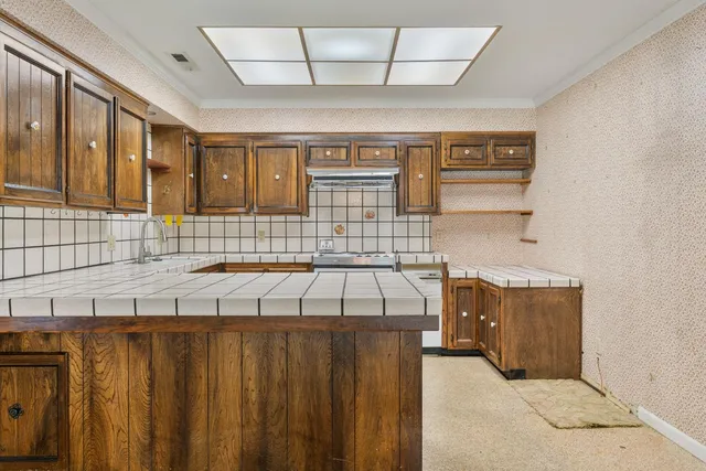 a kitchen with a sink stove and cabinets