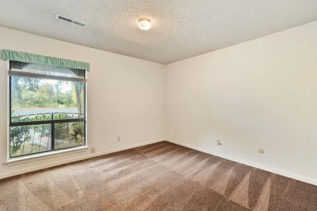a bathroom with a granite countertop sink a large mirror and a bathtub next to a window