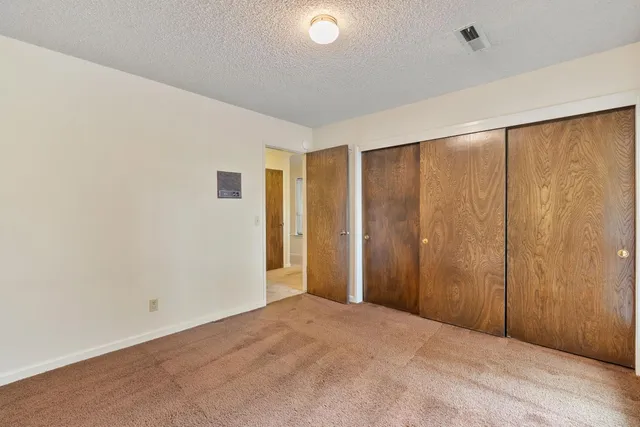 a view of a house with a big yard plants and large trees