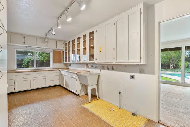 a backyard of a house with large trees and wooden fence