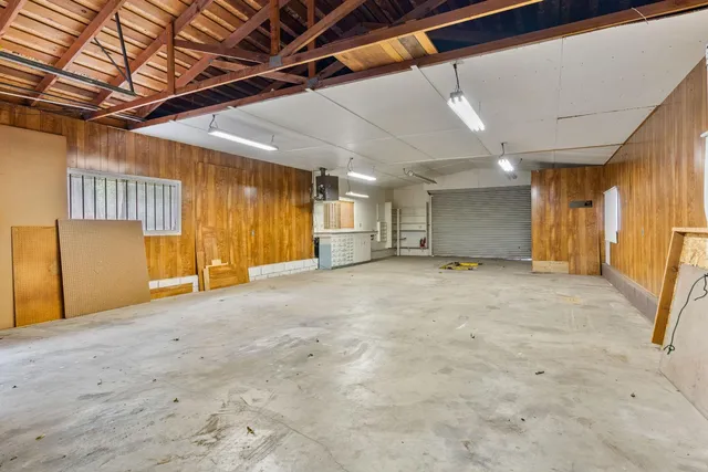 a view of a wooden house with a yard and large trees