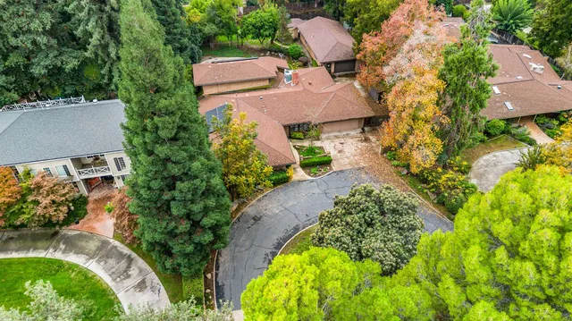 an aerial view of residential houses with outdoor space and trees