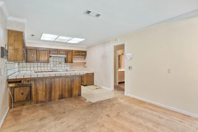 a large kitchen with a stove kitchen island a sink dishwasher and a large refrigerator