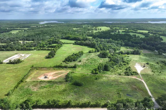 a view of a lush green outdoor space with a lake view and mountain view