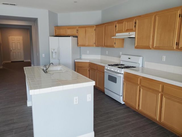 a kitchen with a sink a stove and cabinets