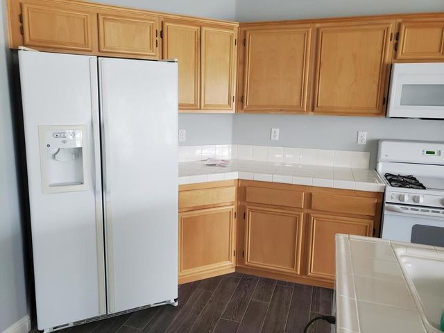 a kitchen with stainless steel appliances granite countertop a refrigerator sink and cabinets