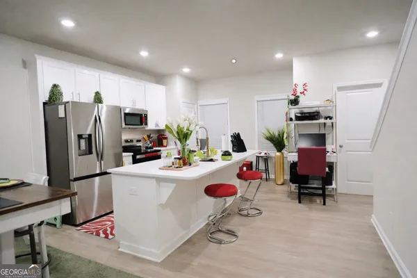 a kitchen with stainless steel appliances a dining table and chairs