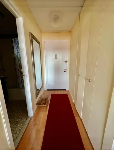 a view of hallway with wooden floor and chair