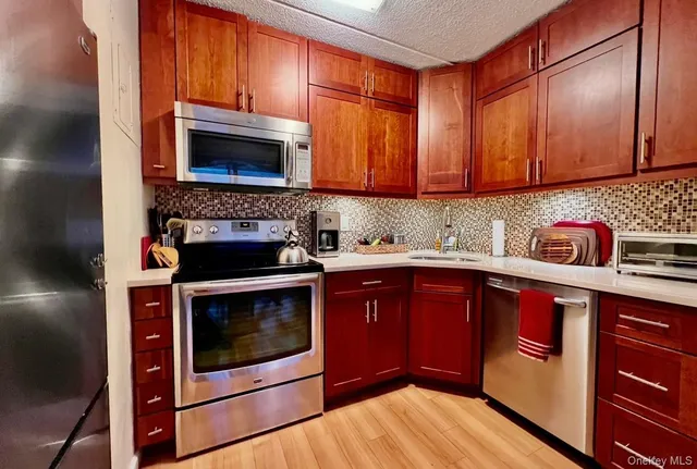 a kitchen with stainless steel appliances granite countertop a stove microwave and sink