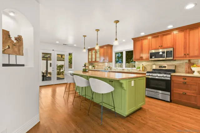 a kitchen with stainless steel appliances granite countertop a stove a sink and a refrigerator