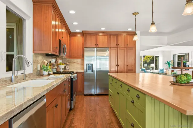 a kitchen with stainless steel appliances granite countertop sink stove and refrigerator