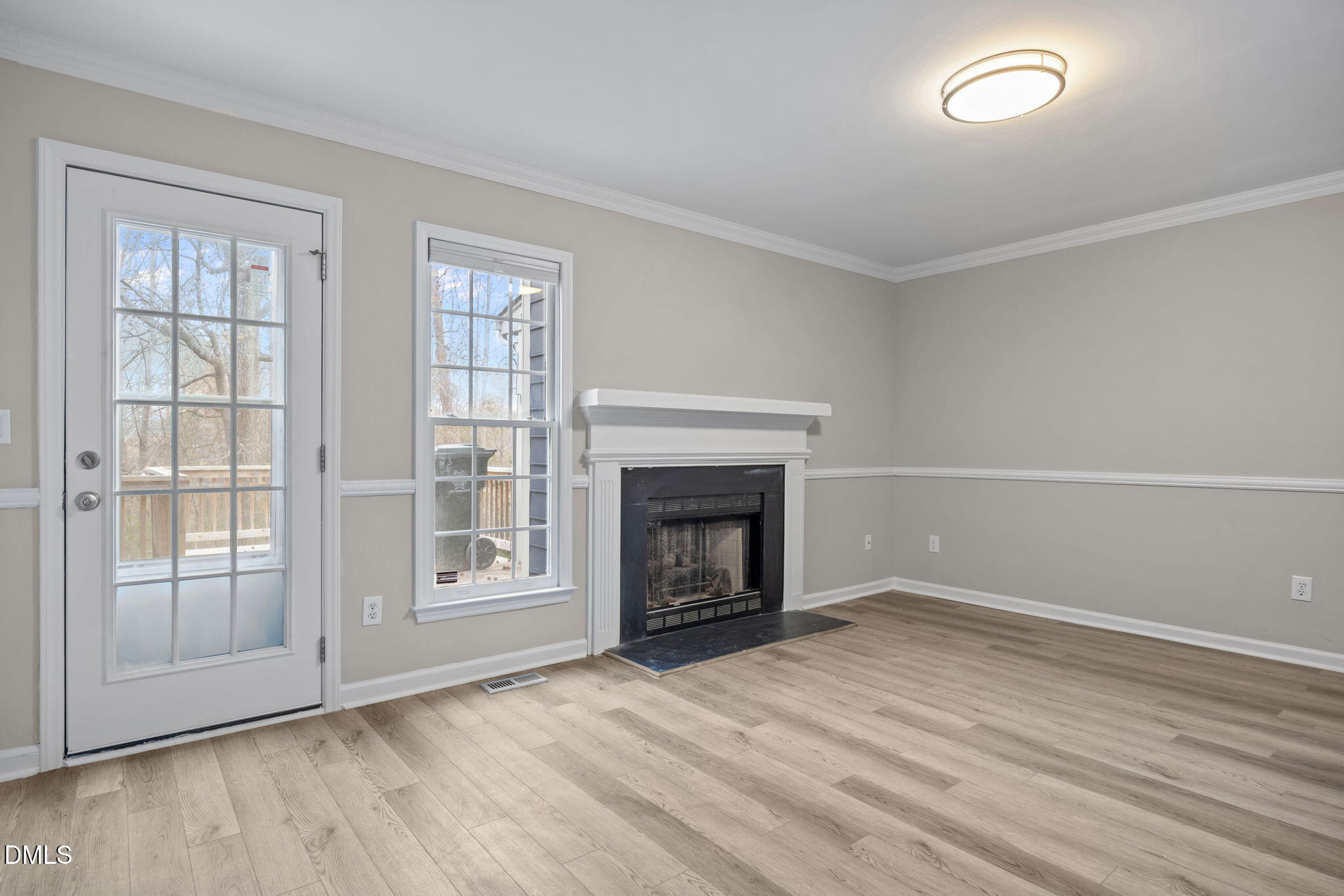 2813 Bedfordshire Court Raleigh, NC 27604 - Photo 6 of 44 an empty room with wooden floor fireplace and windows