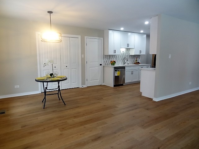 21 Buckingham Road Glen Ellyn, IL 60137 - Photo 12 of 38 a view of a kitchen with kitchen island stainless steel appliances wooden floor and living room view
