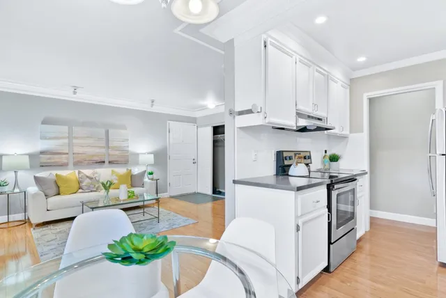 a kitchen with stainless steel appliances kitchen island granite countertop a table and chairs in it