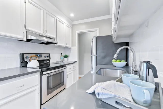 a kitchen with stainless steel appliances granite countertop a sink a stove and a refrigerator