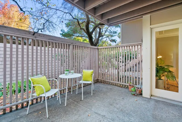 a view of a chairs and table in the back yard of the house