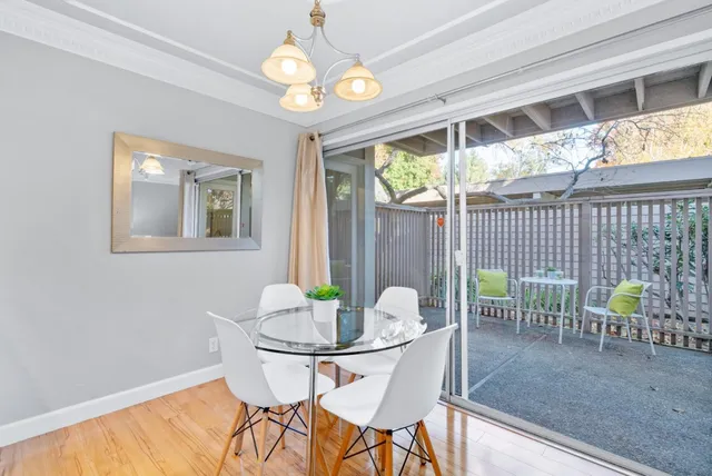 a view of a dining room with furniture a chandelier and wooden floor
