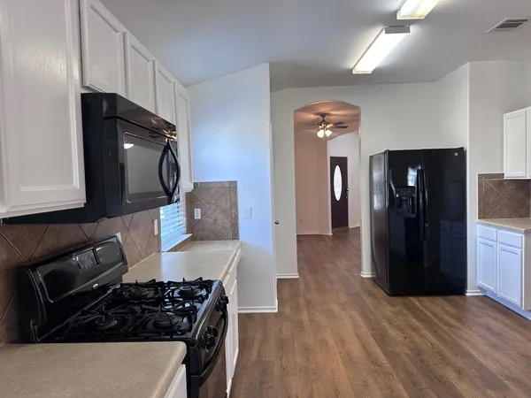 a kitchen with a refrigerator and a stove top oven