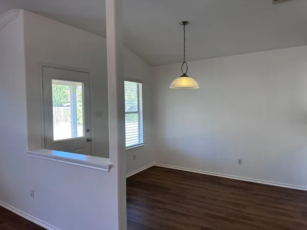 a view of a room with wooden floor and windows