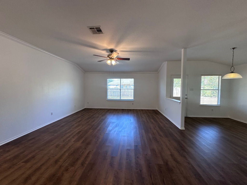 12720 Waynespur Lane Elgin, TX 78621 - Photo 15 of 31 an empty room with wooden floor chandelier and windows
