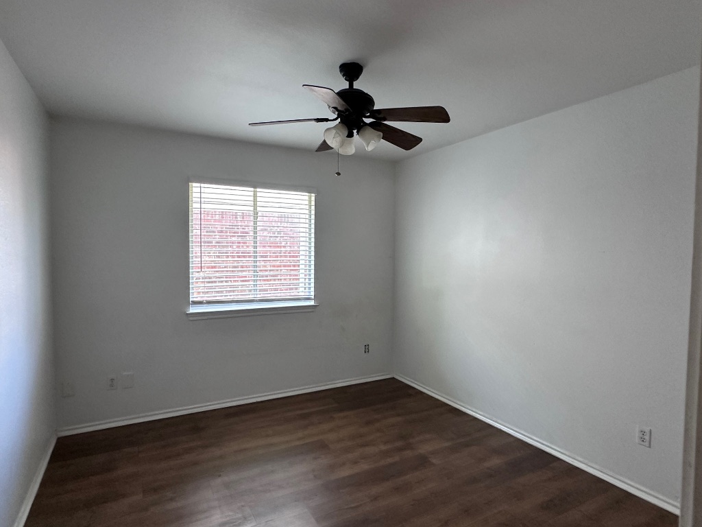 12720 Waynespur Lane Elgin, TX 78621 - Photo 20 of 31 an empty room with wooden floor chandelier fan and windows