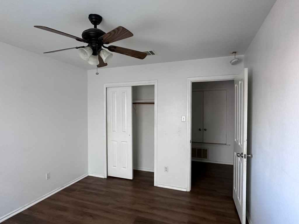 12720 Waynespur Lane Elgin, TX 78621 - Photo 21 of 31 a view of an empty room with wooden floor and a ceiling fan