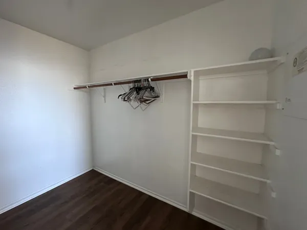 a view of walk in closet with empty racks