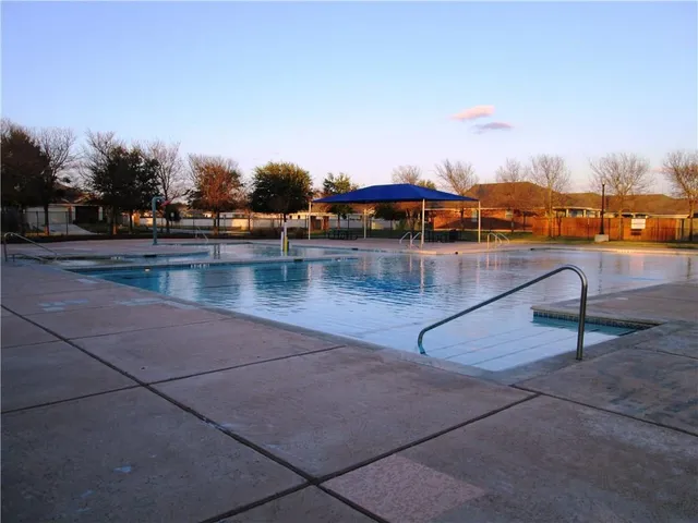 a view of swimming pool with outdoor seating and city view