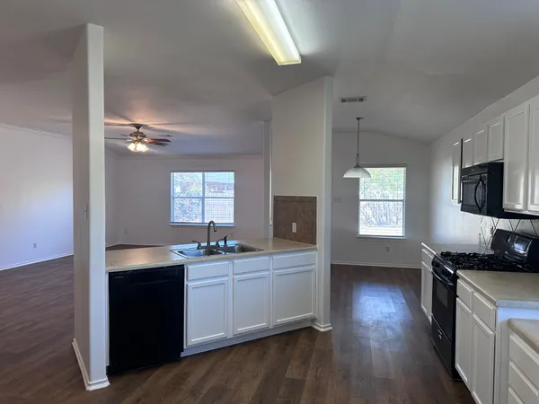 a kitchen with a sink cabinets and wooden floor