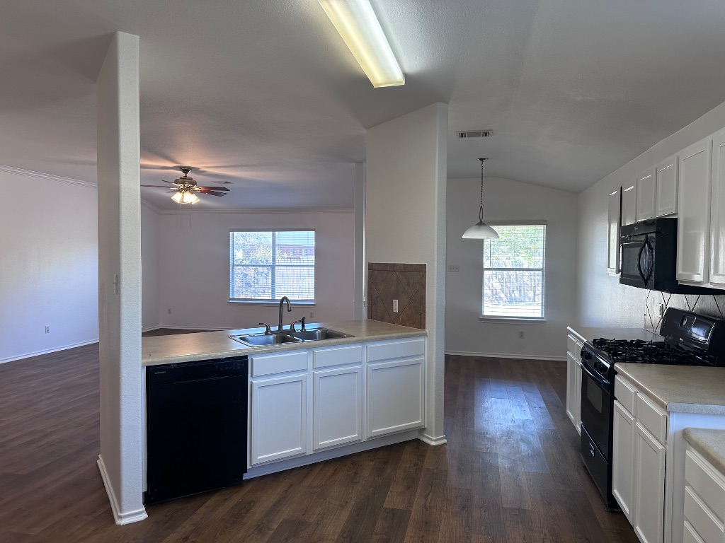 12720 Waynespur Lane Elgin, TX 78621 - Photo 6 of 31 a kitchen with a sink cabinets and wooden floor