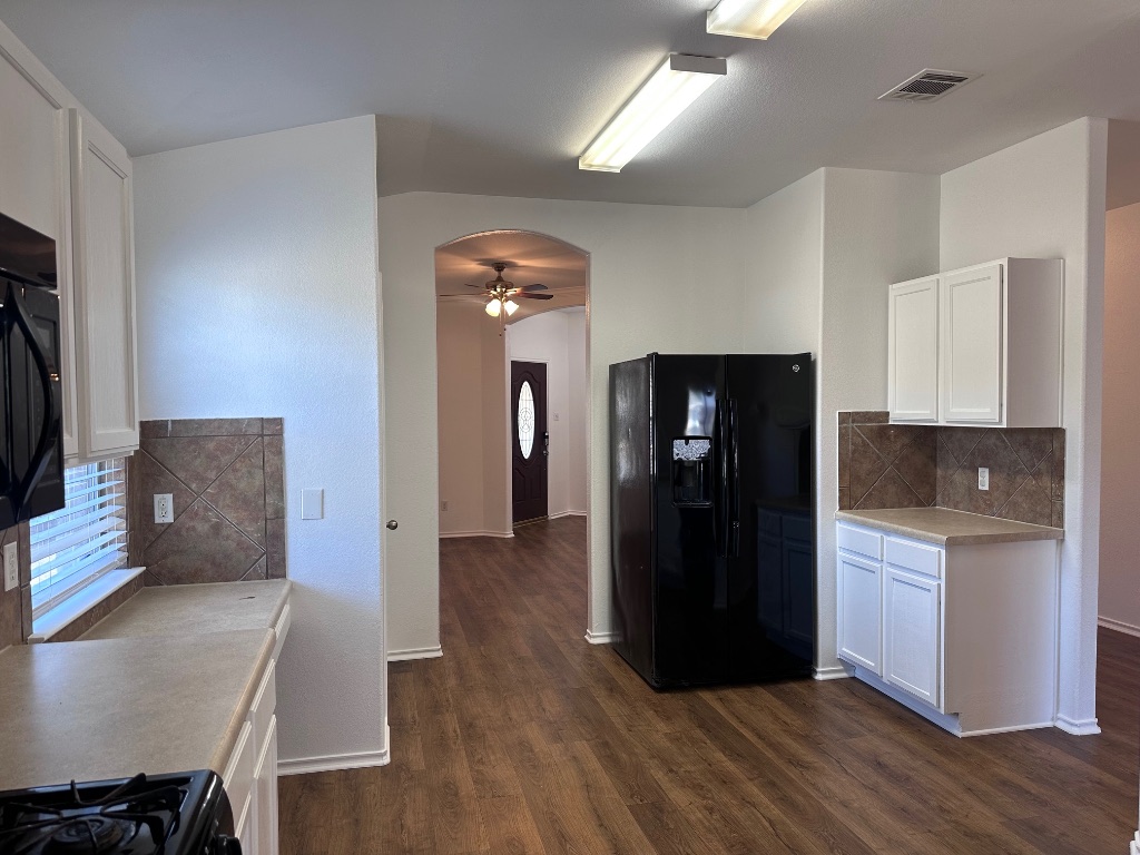 12720 Waynespur Lane Elgin, TX 78621 - Photo 9 of 31 a kitchen with a refrigerator and cabinets