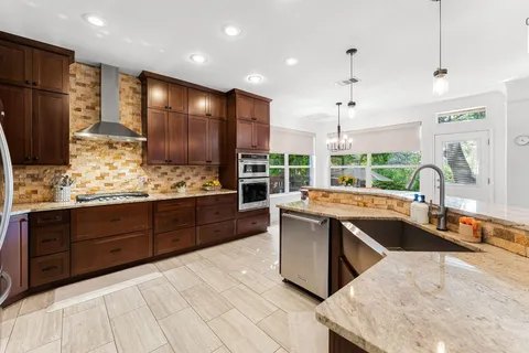a large kitchen with kitchen island granite countertop a large counter top stainless steel appliances and sink