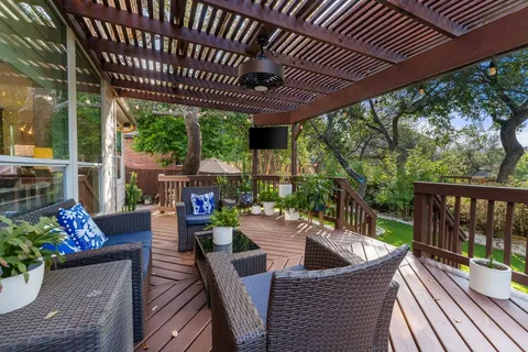 a front view of a house with garden and a patio