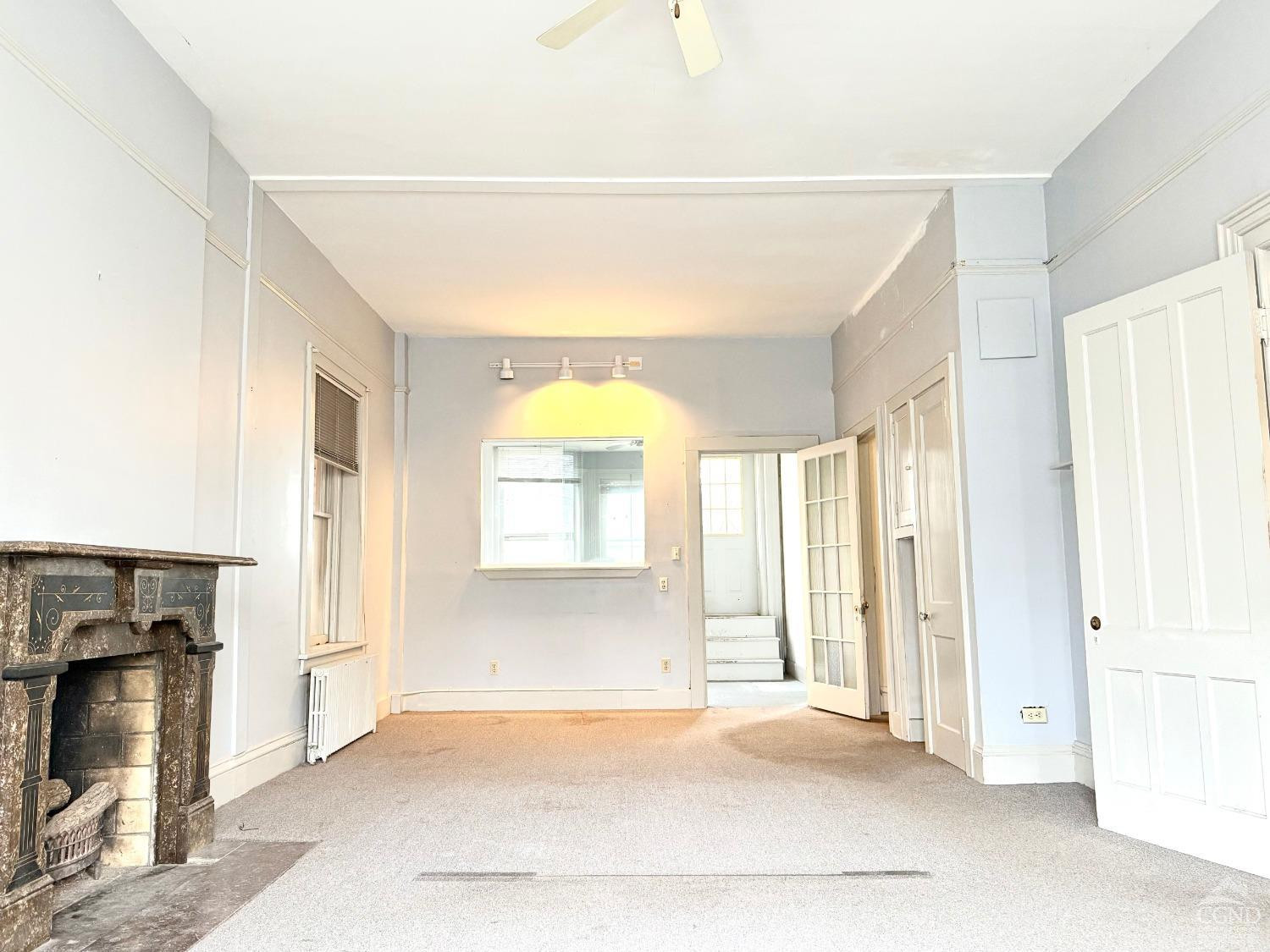283 Main Street Catskill, NY 12414 - Photo 4 of 25 a view of an empty room with a fireplace and a window