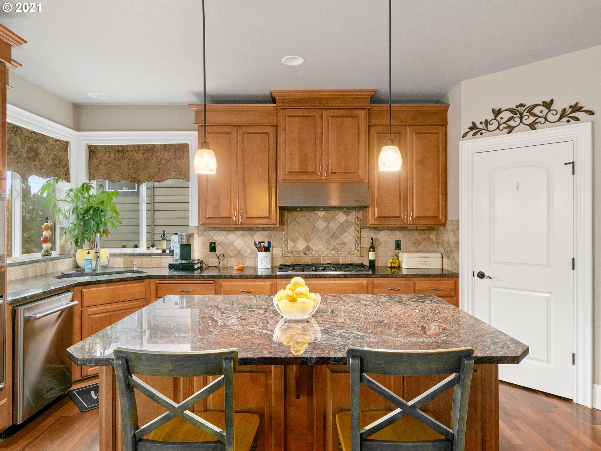 14741 Southeast Badger Creek Road Happy Valley, OR 97086 - Photo 11 of 32 a kitchen with stainless steel appliances granite countertop wooden cabinets a sink a stove a dining table and chairs