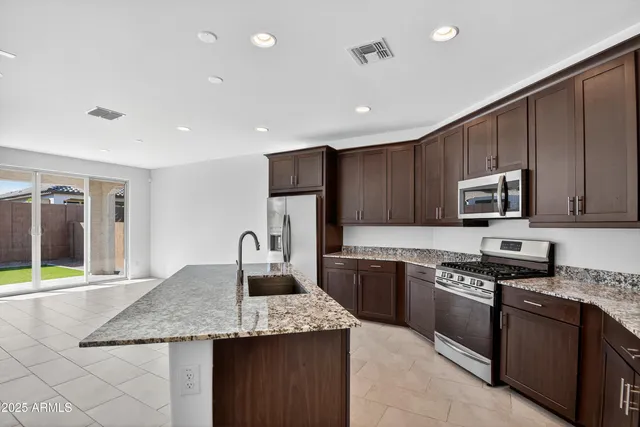 a kitchen with stainless steel appliances granite countertop a stove sink and cabinets