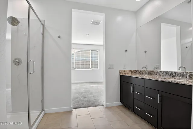 a bathroom with a granite countertop sink a mirror and a shower