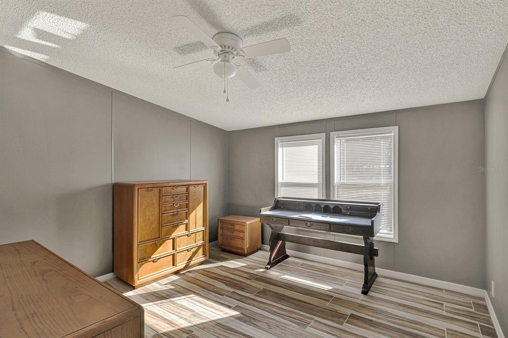 141 Woods Road San Mateo, FL 32187 - Photo 17 of 66 a living room with a bed and a chandelier