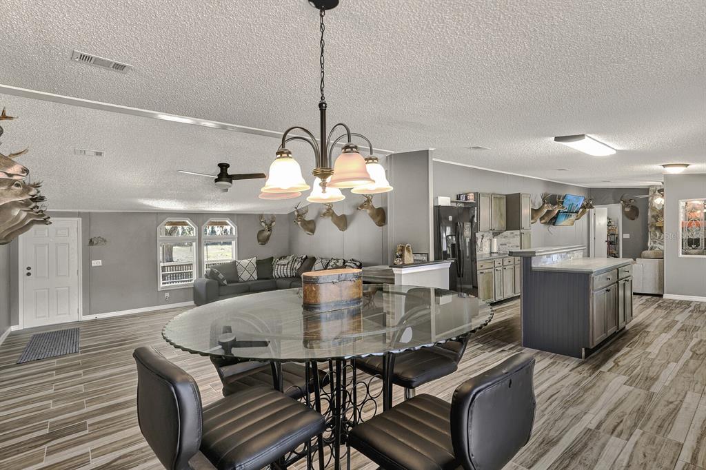 141 Woods Road San Mateo, FL 32187 - Photo 24 of 66 a dining room with furniture a chandelier and wooden floor