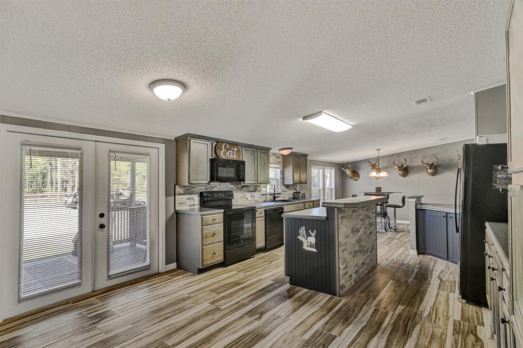 141 Woods Road San Mateo, FL 32187 - Photo 27 of 66 a kitchen with stainless steel appliances kitchen island granite countertop a stove top oven and refrigerator