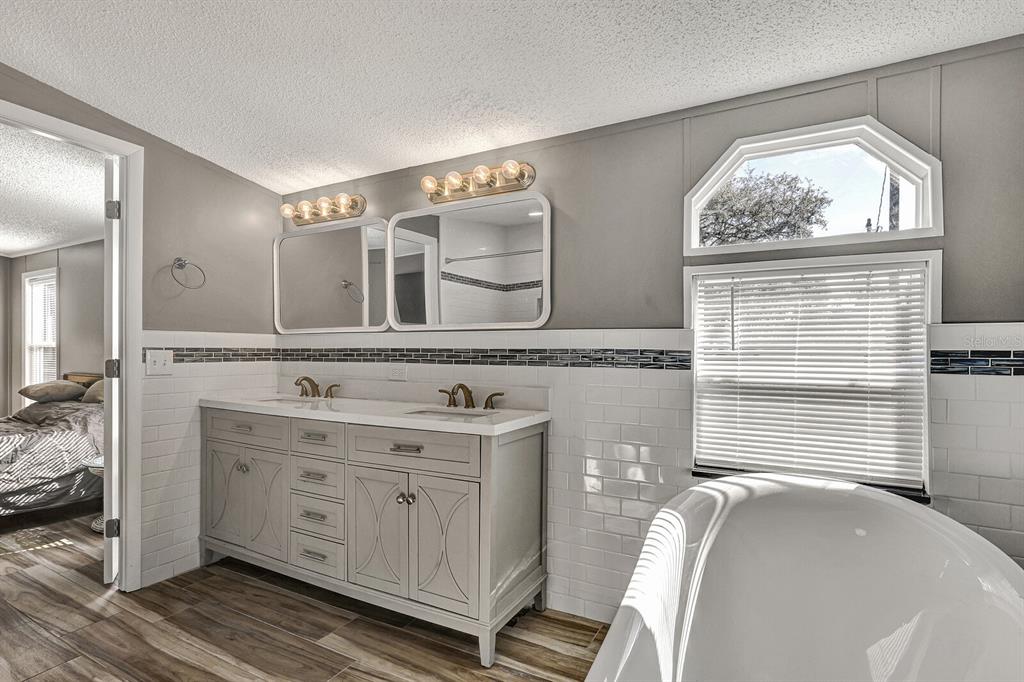 141 Woods Road San Mateo, FL 32187 - Photo 33 of 66 a spacious bathroom with a double vanity sink a mirror and a window