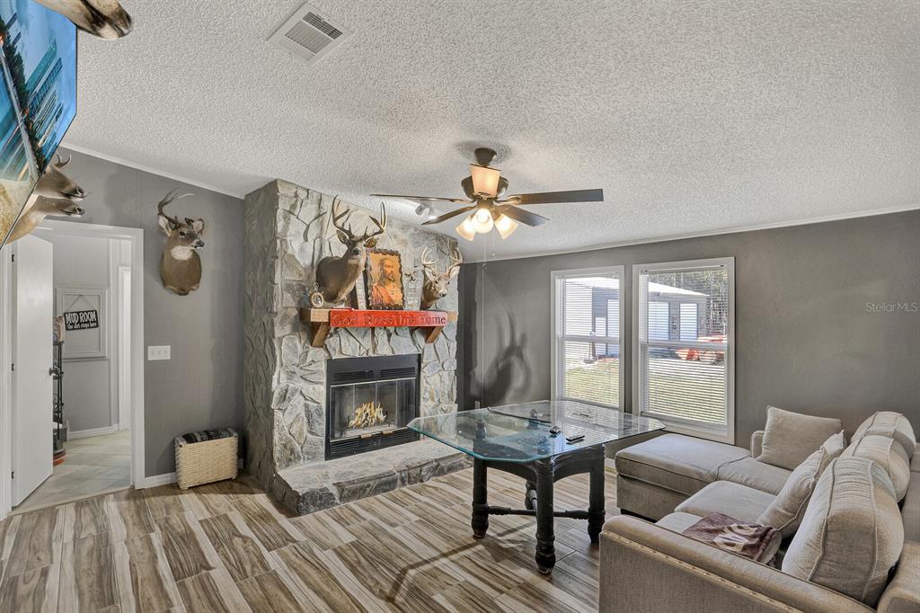 141 Woods Road San Mateo, FL 32187 - Photo 36 of 66 a living room with furniture a fireplace and a flat screen tv